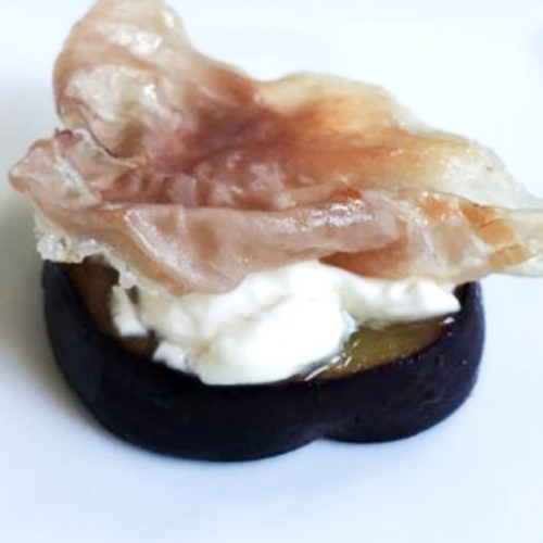 prosciutto and cream cheese topped plum slice